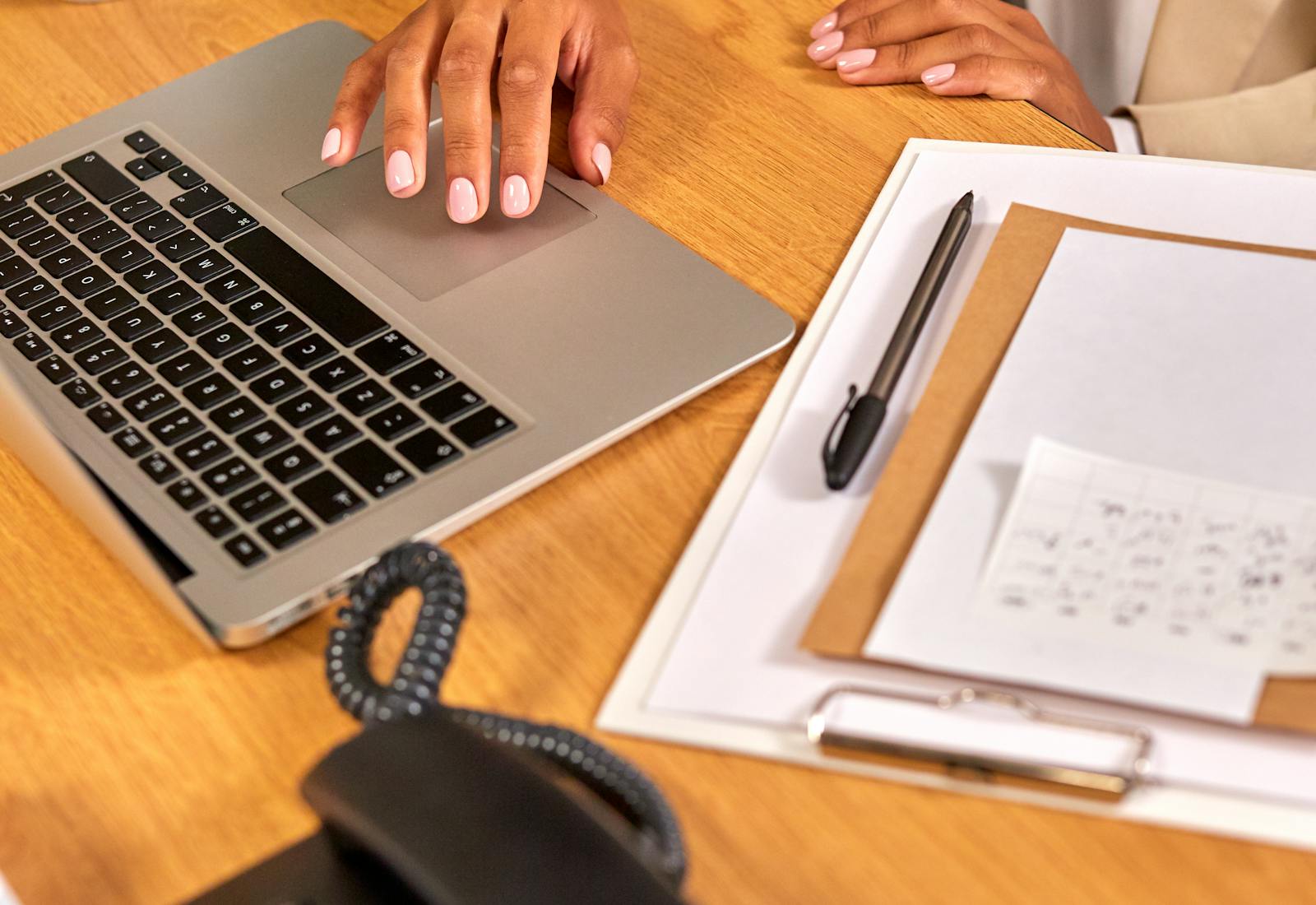 Professional desk with phone, notebook, laptop, and business papers